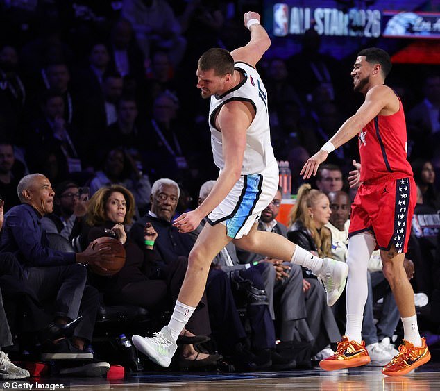 NBA ऑल-स्टार गेममध्ये मिशेलसोबत कोर्टसाइड बसून ओबामा एक सैल चेंडू पकडतो