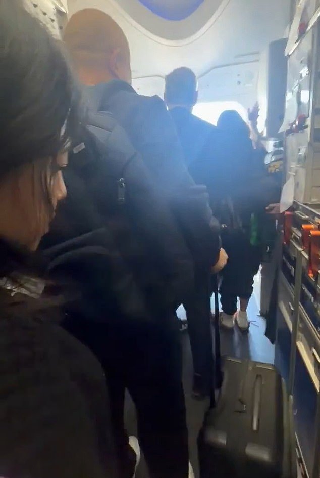 लॉस एंजेलिस विमानतळावर इंजिन उतरल्यानंतर स्लाइड्स तैनात केलेल्या युनायटेड बोईंग 787 च्या आणीबाणीच्या वेळी प्रवासी सामान घेऊन जाताना दिसतात.